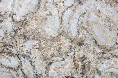 Variegated wall surface in beige, brown and gray-blue tones with black striped patches.