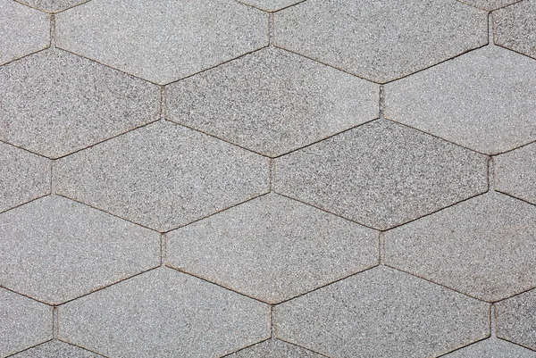 Background and texture of pressed waterproof diamond-shaped gray bituminous slabs for use in the construction of building roofs. Background and texture of small crumbs, close-up.