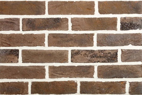 The wall is lined with vintage rough bricks in a horizontal design. Wall texture with contrasting light cement joints.
