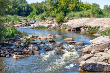 Kayalık kıyılar boyunca akmakta olan hızlı bir orman deresi..