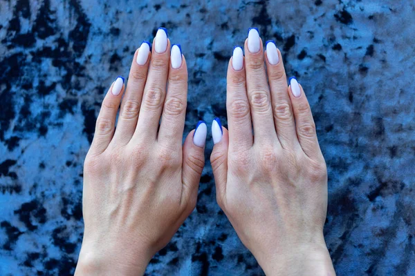 Mãos Femininas São Dobradas Lado Uma Bela Manicure Francesa Colorida — Fotografia de Stock
