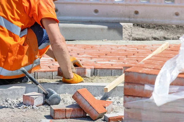 Bricklayer Κατάληψη Προσεκτικά Τοποθέτηση Πλάκες Πορτοκαλί Πλακόστρωτο Ένα Μονοπάτι Μια — Φωτογραφία Αρχείου