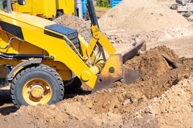 Tekerlekli buldozerin güçlü pnömatik sürgülü kovası toprak çalışma platformunun düzleştirilmesi üzerinde çalışır..