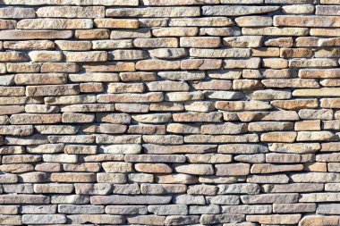 Güneş ışığıyla aydınlatılan büyük bir nehir taşı duvarı..