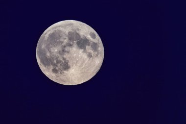 Close-up of the full moon illuminating the night sky. clipart