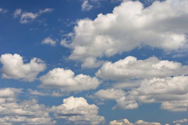 Beyaz kabarık bulutlar parlak mavi gökyüzüne yayıldı güneş ışığı içinden geçerken, huzurlu ve huzurlu bir atmosfer oluşturdu, dingin bir gökyüzü kavramı.