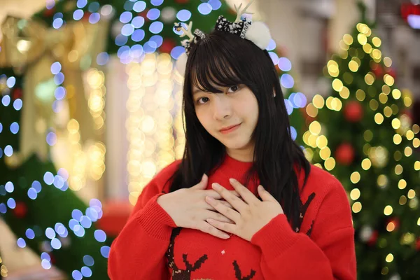 美しいですアジアの若いです女性とともに赤いセーターとともにクリスマスツリーライト — ストック写真