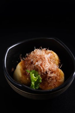 Japon kızartılmış Agedashi tofu Japon aperatifi. Sos zencefilli kızarmış tofu ve siyah arka planda izole edilmiş yeşil soğan sosu.