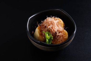 Japon kızartılmış Agedashi tofu Japon aperatifi. Sos zencefilli kızarmış tofu ve siyah arka planda izole edilmiş yeşil soğan sosu.