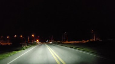 Gece kırsal kesimde araba kullanmak. Ön cam ve gerçek zamanlı bakış açısı.