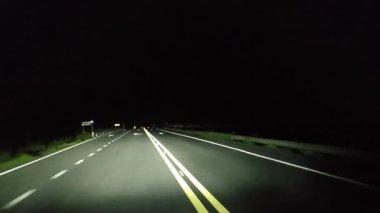Gece kırsal kesimde araba kullanmak. Ön cam ve gerçek zamanlı bakış açısı.