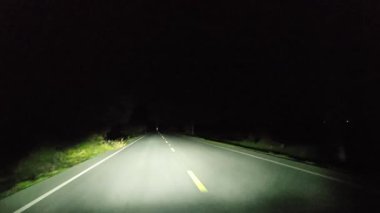 Gece kırsal kesimde araba kullanmak. Ön cam ve gerçek zamanlı bakış açısı.