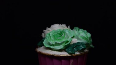 Siyah arkaplanda Rose cupcake rotasyonu.