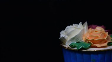 Siyah arkaplanda Rose cupcake rotasyonu.