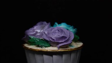 Siyah arkaplanda Rose cupcake rotasyonu.