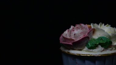Siyah arkaplanda Rose cupcake rotasyonu.