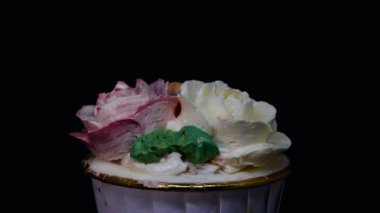 Siyah arkaplanda Rose cupcake rotasyonu.