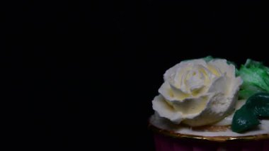 Siyah arkaplanda Rose cupcake rotasyonu.