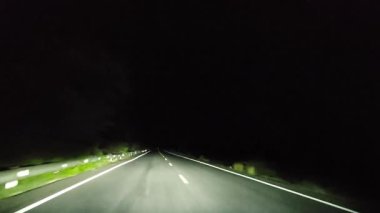 Gece kırsalda araba sürerken arabanın ön camına bakarak bakış açısı. 