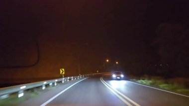 Gece kırsalda araba sürerken arabanın ön camına bakarak bakış açısı. 