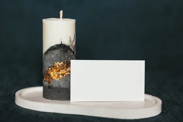 An incredibly beautiful candle on a clean background. Handmade wax and concrete candle with gilding. Holiday advent. With space for your text