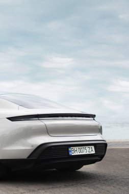 Odessa, Ukrayna - 5 Eylül 2021: Arka planda elektrikli Porsche Taycan