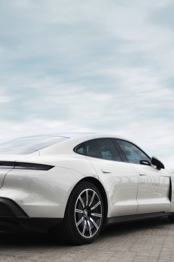 Odessa, Ukrayna - 5 Eylül 2021: Arka planda elektrikli Porsche Taycan