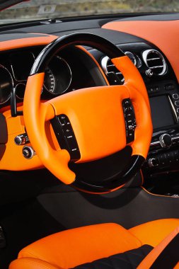 Gösterge panelini gösteren modern bir otomobilin iç görüntüsü. Akort. Turuncu lüks araba