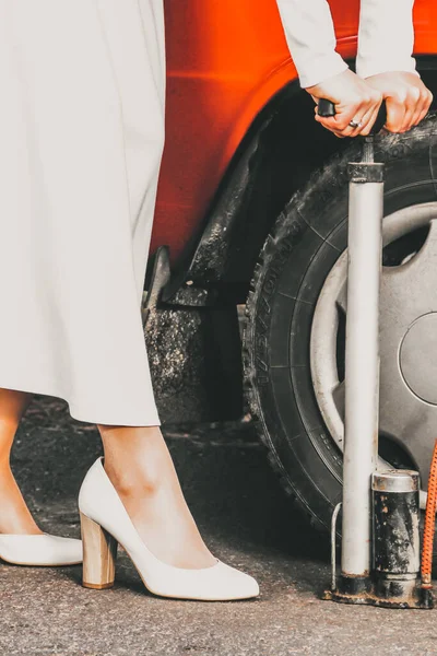Девушка Белом Свадебном Платье Надувает Колесо Машине — стоковое фото