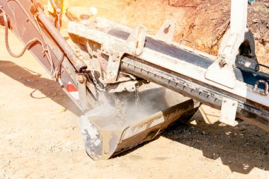 Concrete mixer truck pouring fresh wet concrete into excavators bucket at a construction site