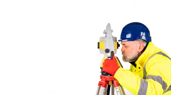一位建筑工人 戴着蓝色的帽子 穿着黄色的反光外套 白色的背景上有文字的空间 在白色背景上使用现代测量设备隔离的勘测员 — 图库照片