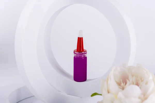 eyebrow paint in pink tubes on a pink prop on a white background