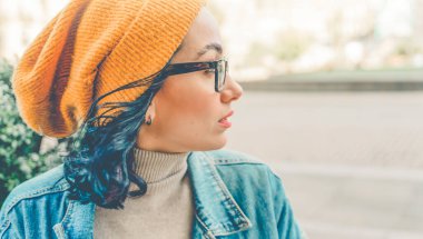 portrait of woman  in yellow hat and denim coat drinking coffee in the cafe