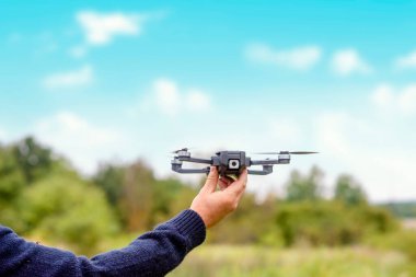 man using a drone with remote controller  making photos and videos,  having fun with new  technology trends