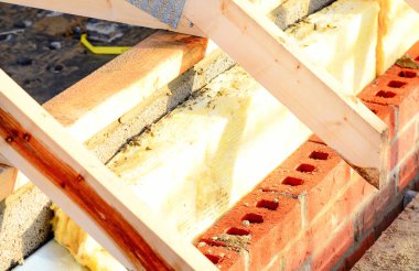 Insulating walls of new build houses by placing rock wool inside wall cavities as part of the energy-saving measures close-up. House insulated with mineral wool to reduce energy bill