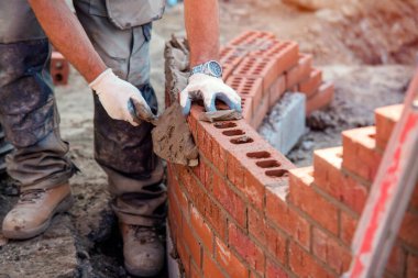 Bricklayer working on a curved wall clipart
