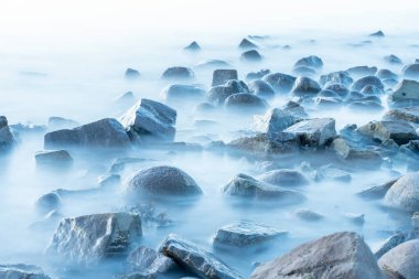 Kaya plajı, deniz ve bulutlu mavi gökyüzü güneşli bir günde