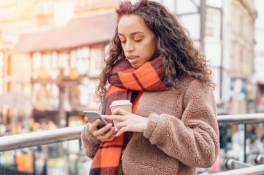 Outdoor portrait of an upset woman using a mobile phone visiting a Europe city