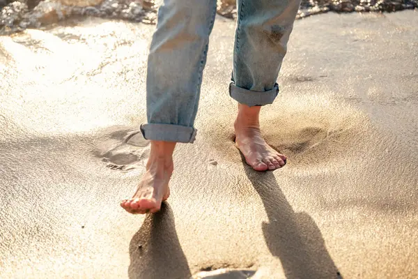 Close up of woman feet walking barefoot on seaside . Vacation, travel and freedom concept. People relaxing in summer.