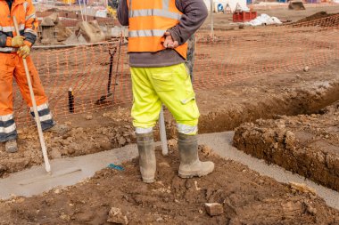 İnşaat alanında taşınabilir beton pompa. İnşaatçılar ev temellerini ıslak hazır betonla dökerler.