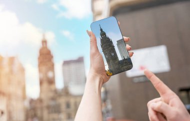 Cep telefonu tutan ve ekranı gösteren bir kadın. Hedefe ulaşıyor. Manzaraları bul. Seyahat yaşam tarzı konsepti