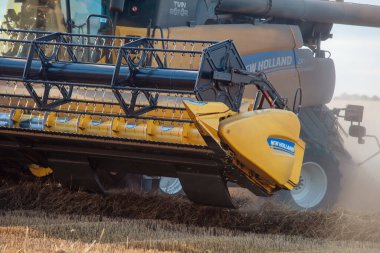 Yorkshire, İngiltere - 3 Ağustos 2022, New Holland. Modern bir biçerdöver tarafından yaz mevsiminde buğday hasadı. Çiftçiler yiyecek tedarik ediyor ve ulusu besliyor.