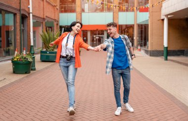 İki arkadaş, kamera kullanan bir çift, kırmızı bir telefon kulübesine selfie çekiyor, kamerada fotoğraf izliyor, İngiltere 'de eğleniyor. Seyahat yaşam tarzı konsepti.