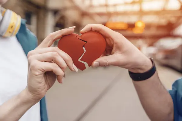 Couple trying to connect two pieces of paper heart - relationship, in love concept