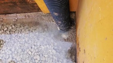 Kanalizasyon çalışmaları sırasında siper kutusunun içinden yeraltı suyu pompalamak. Su taşlardan ve çakıllardan akıyor.