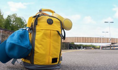 Sarı çantalı, kulaklık takan ve tren istasyonundaki platformda duran. Seyahat konsepti. hafif seyahat