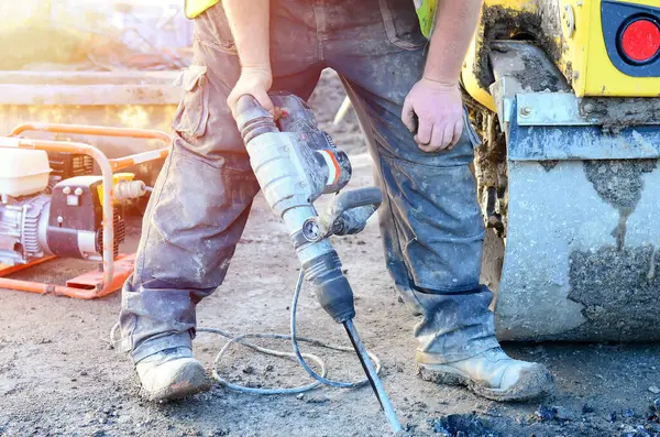 stock image Builder breaking asphalt with electric breaker