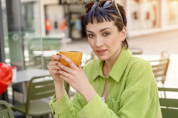 woman having coffee at the street cafe outside, talking on the phone and  having fun time. lifestyle concept