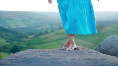 Mavi elbiseli Asyalı kadın ve elinde lavanta buketi olan bir şapka yaz günbatımında dağın tepesinde.