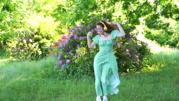 Outdoor Portret Van Vrolijke Rode Haar Vrouw Groene Jurk Koptelefoon — Stockvideo